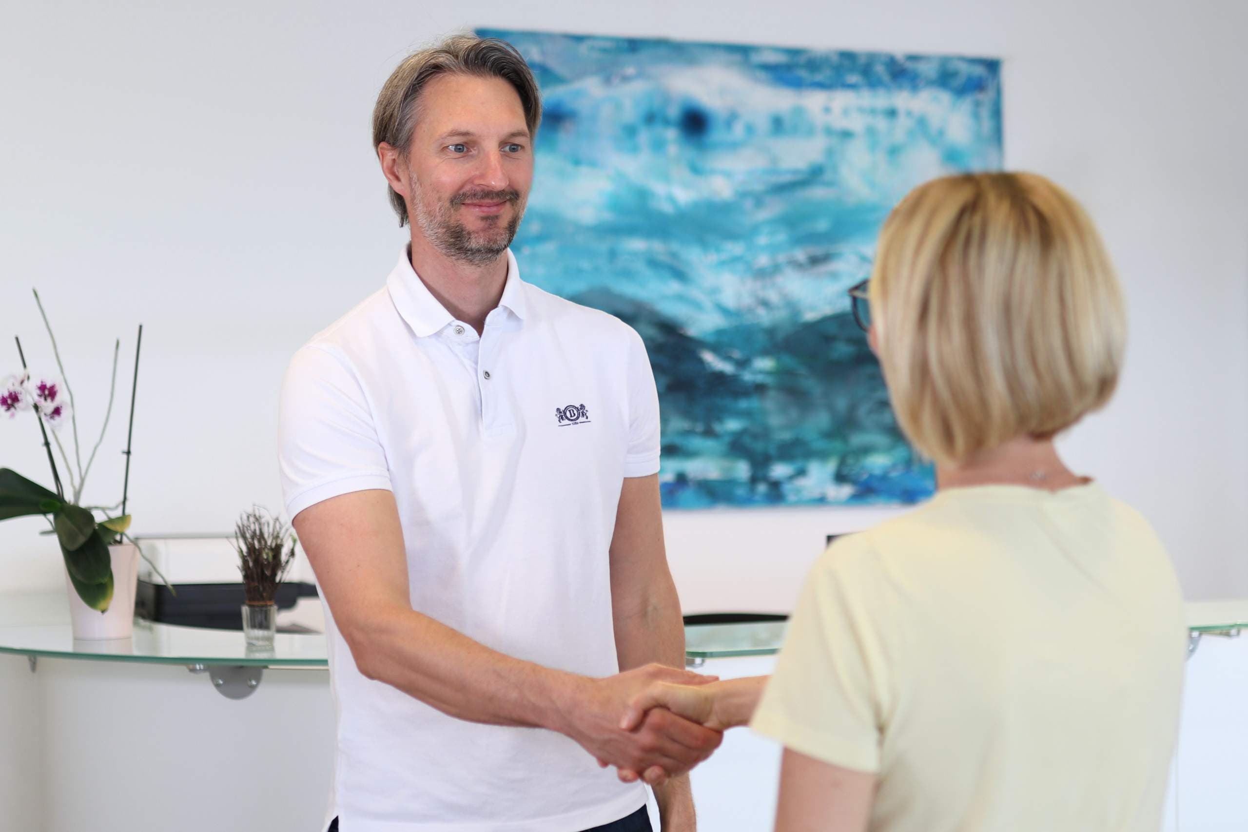 Dr. Christopher Atzlinger begrüßt eine Patientin in der Praxis MR Regau